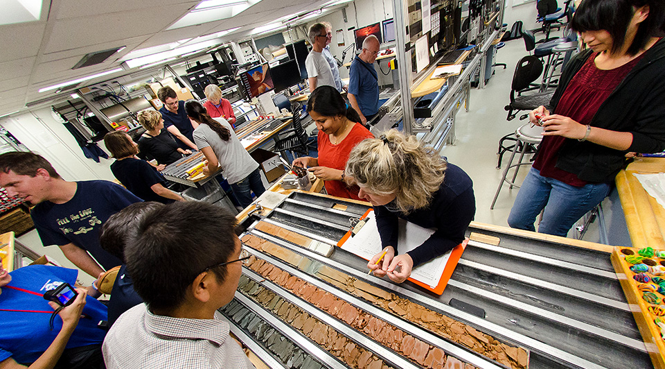 IODP Expedition 362 scientists examine the working and archive halves of a freshly split core.