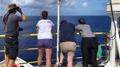 Teilnehmer an Deck mit Blick auf das Korallenatoll Îles Maria.