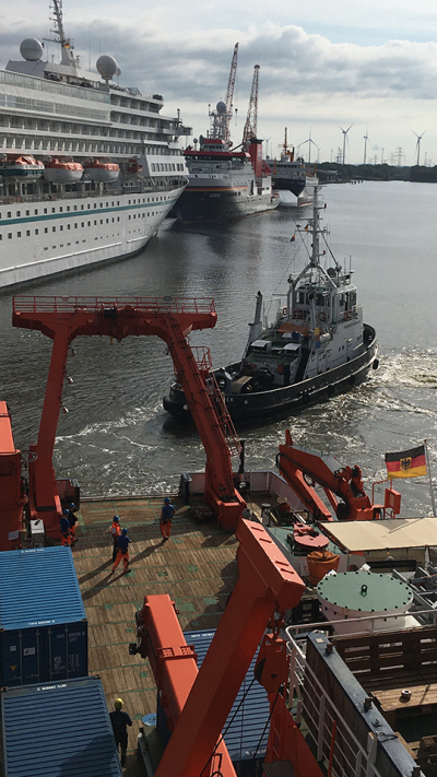 Ein Schlepper zieht die FS METEOR zur Schleuse. Das Forschungsschiff Sonne liegt am Kai in Emden.