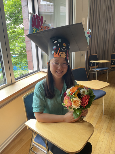 Nan Xiang with her doctoral hat and a flower buquet