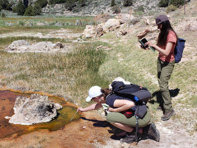 Janina is taking the water temperature in a small pond while a colleague is taking notes