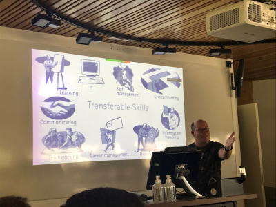 A man in fron of a screen with a slide about 'Transferable Skills'