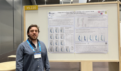 Andrés standing next to his poster at EGU 2023