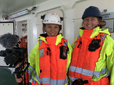 Saskia und Ramona machen neben ihrer Schichtarbeit an Bord auch ein Medienprojekt, für das sie heute in voller Sicherheitsmontur im Beiboot filmen dürfen. Foto: MARUM