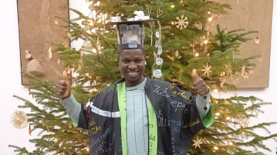 Emmanuel Okuma with his doctoral hat
